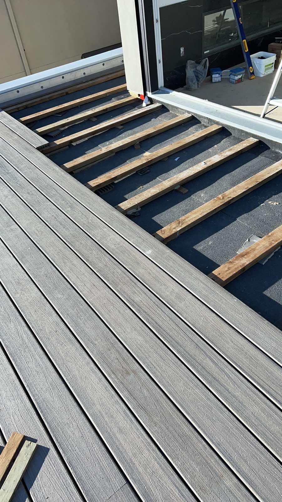 New wood deck framing with composite deck boards stacked ready for install
