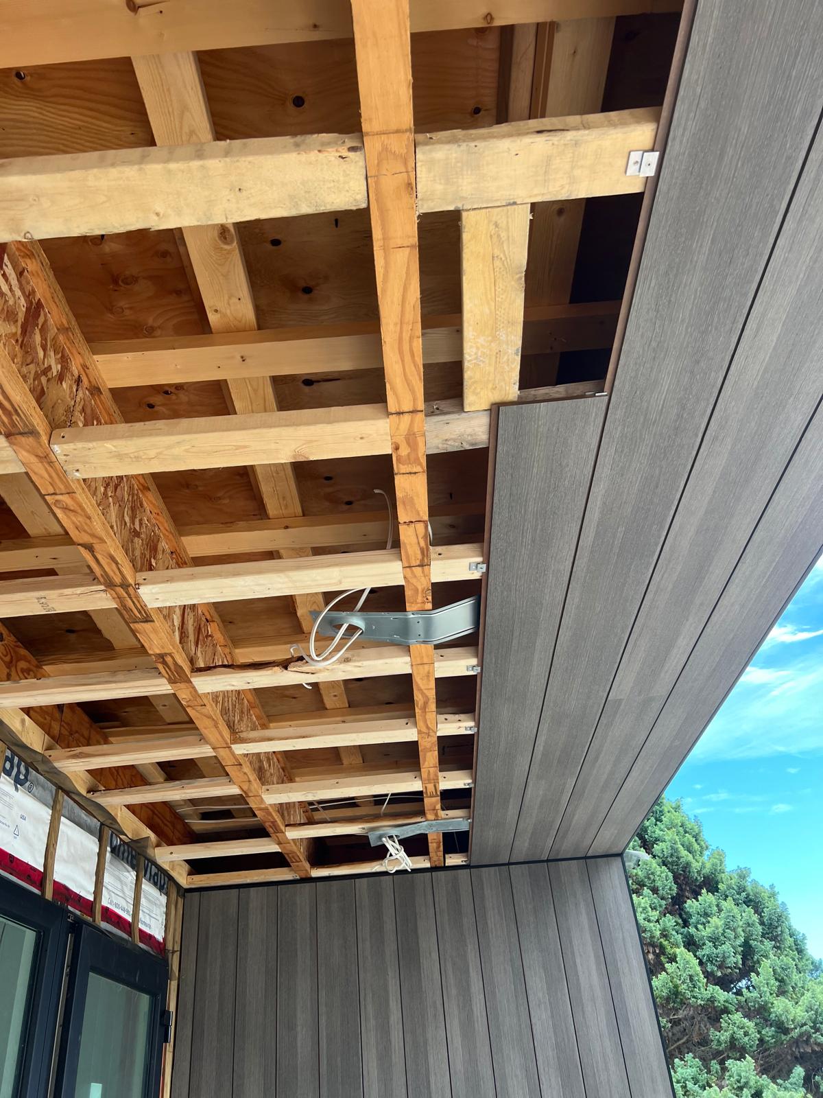 Open overhang with exposed wood framing before soffit installation